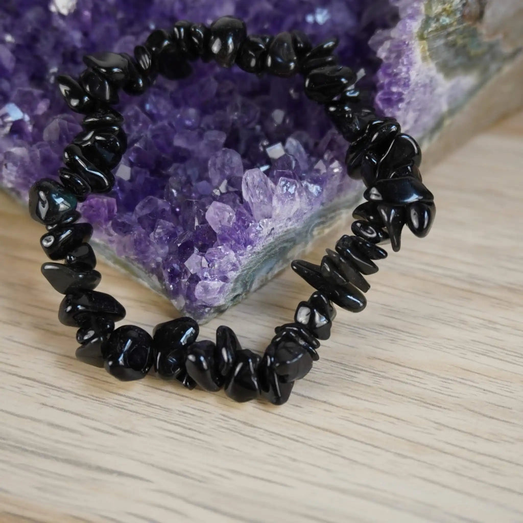 Schwarzer Achat Splitterarmband vor Amethyst Kristallen