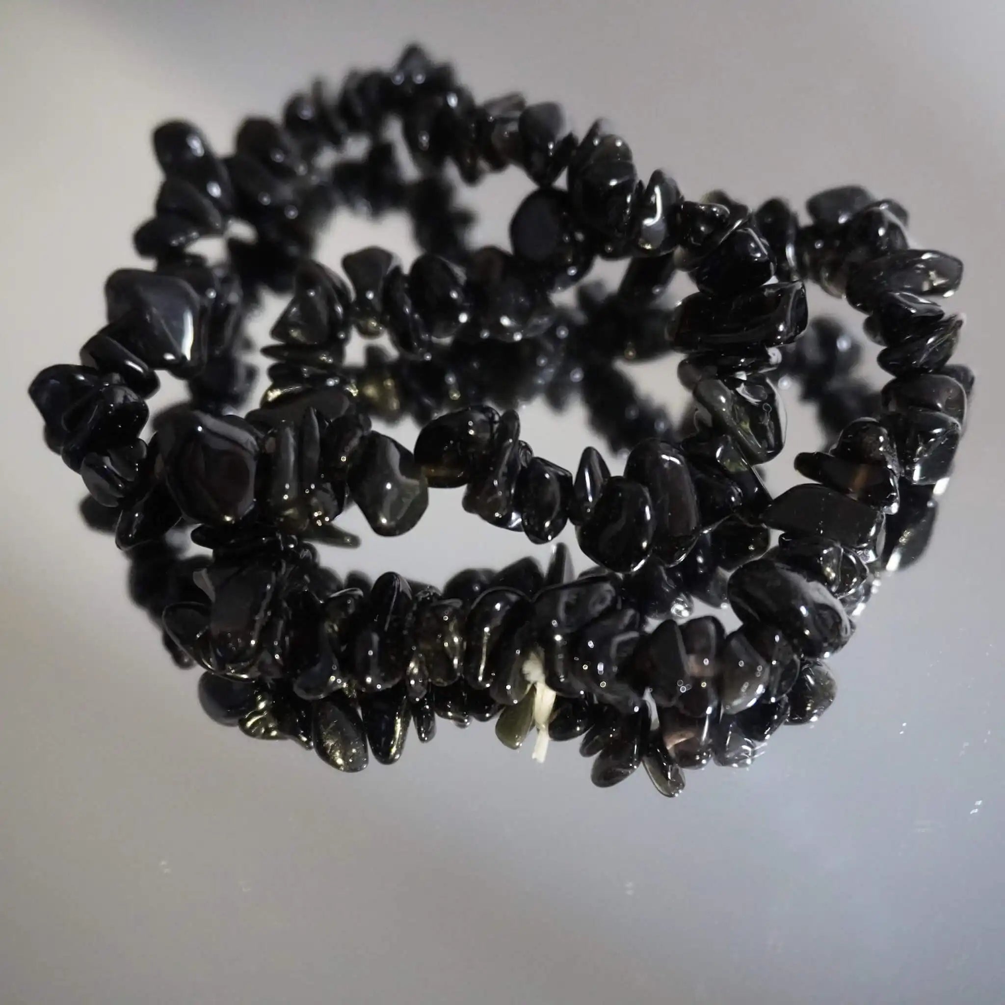 Schwarzer Achat Splitterarmband mit Spiegelung auf glänzendem Untergrund