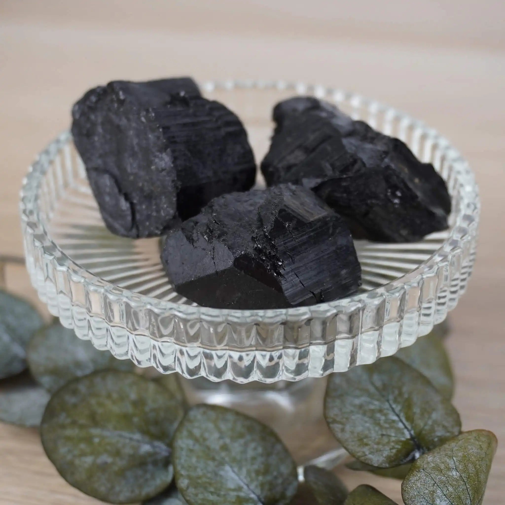 Drei schwarze Turmalin Rohsteine in einer Glaskristallschale