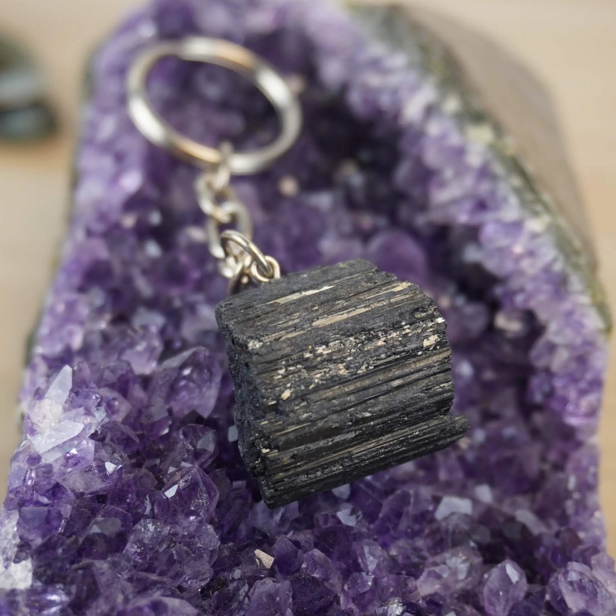 Schwarzer Turmalin Schlüsselanhänger präsentiert auf violetter Amethyst-Druse