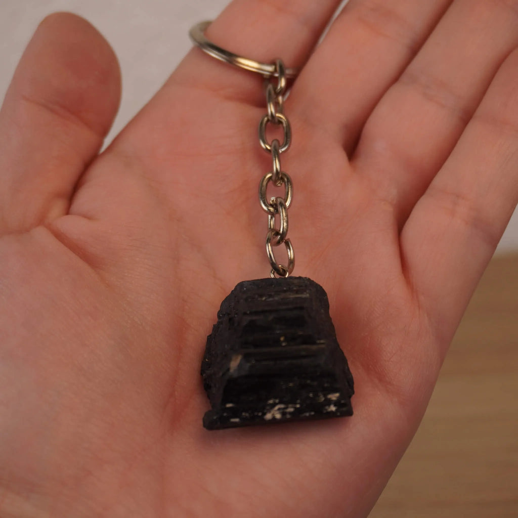 Schwarzer Turmalin Schlüsselanhänger in einer geöffneten Hand gehalten