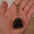 Schwarzer Turmalin Schlüsselanhänger in einer geöffneten Hand gehalten