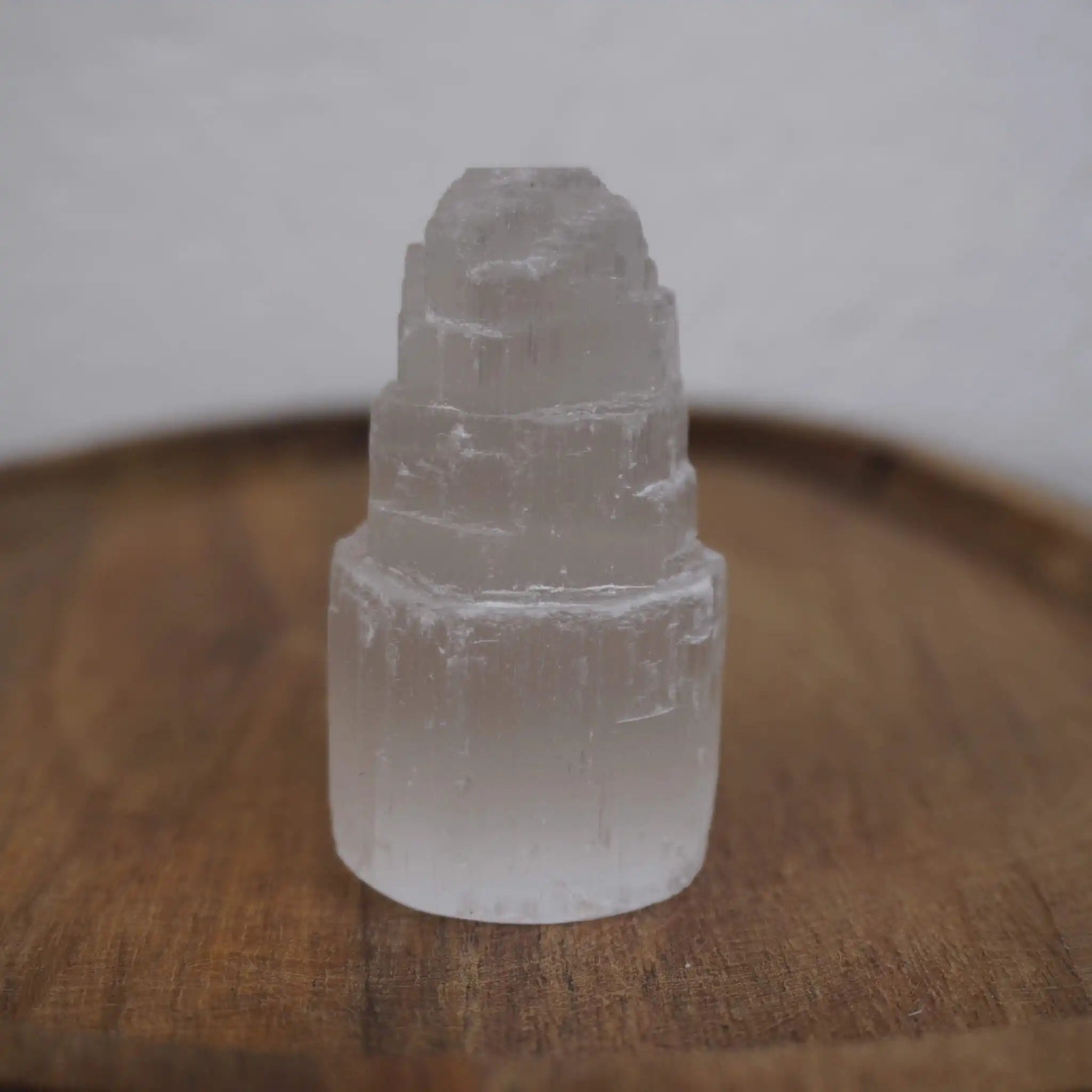 Selenit Turm Kristall auf Holzunterlage