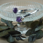 Silberarmreif mit zwei Roh Amethysten auf Glasständer mit Eukalyptus dekoriert