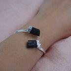 Silberarmreif mit zwei rohen schwarzen Turmalinen am Handgelenk getragen