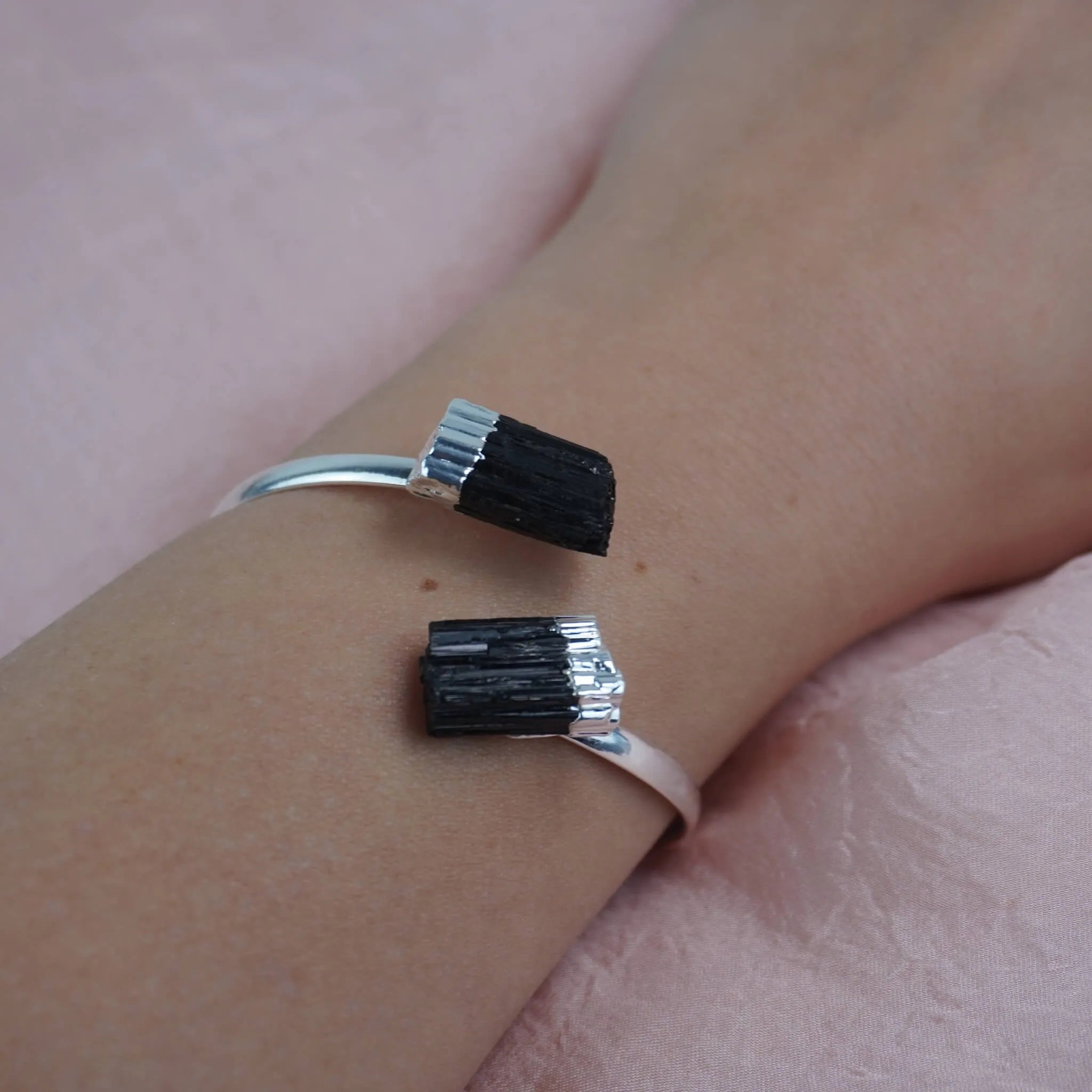 Silberarmreif mit zwei rohen schwarzen Turmalinen am Handgelenk getragen