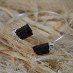 Silberarmreif mit zwei rohen schwarzen Turmalinen auf hellen Naturfasern dekoriert