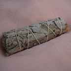 Smudge Stick aus weißem Salbei auf rosa Stoffuntergrund