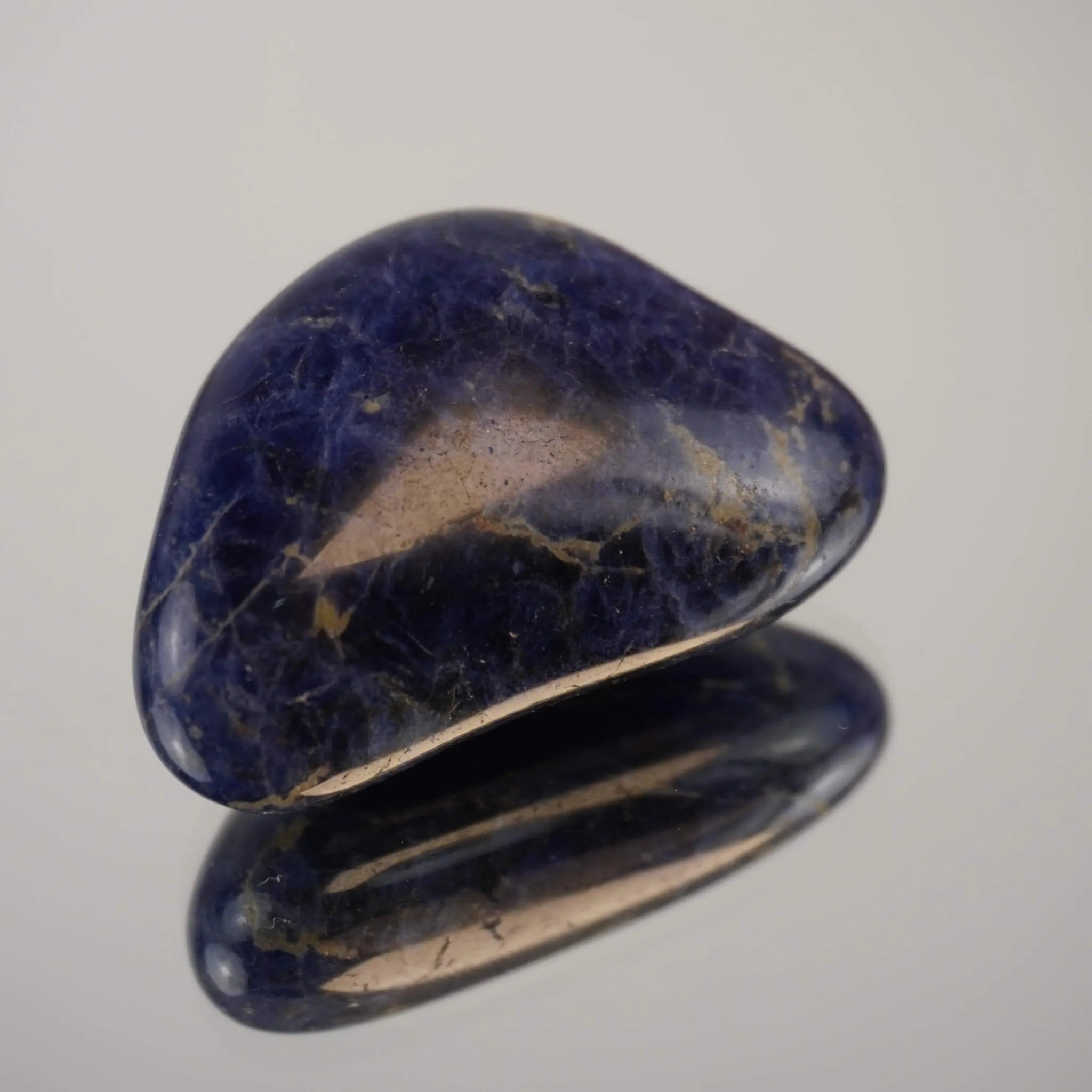 Sodalith Trommelstein als Einzelstein auf spiegelnder Fläche mit Reflexion