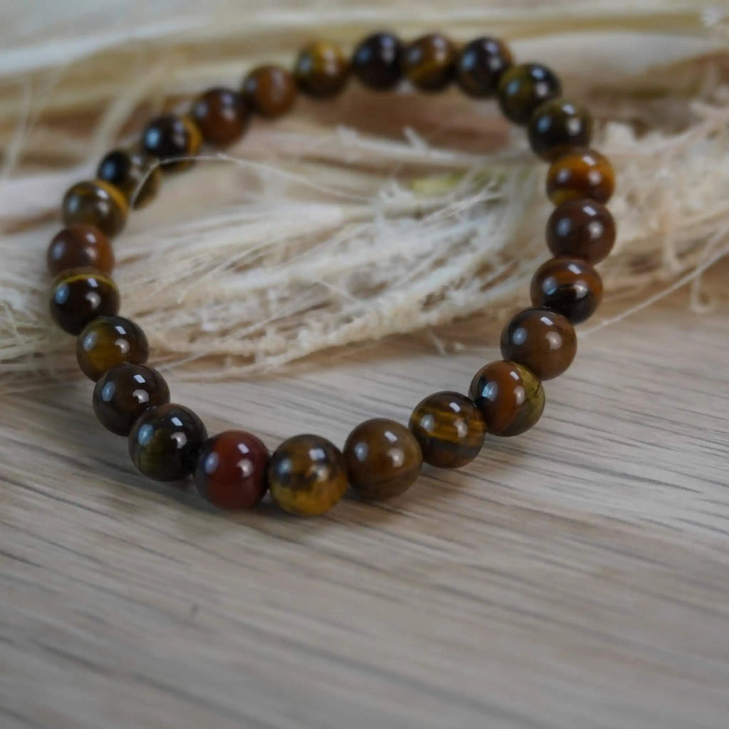 Tigerauge Kugelarmband dekorativ auf Naturmaterialien gelegt