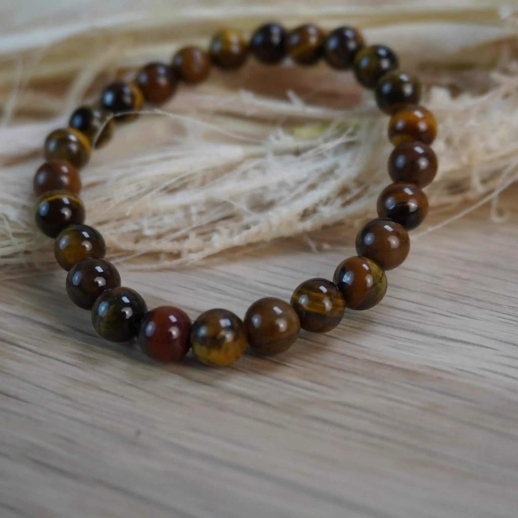 Tigerauge Kugelarmband dekorativ auf Naturmaterialien gelegt