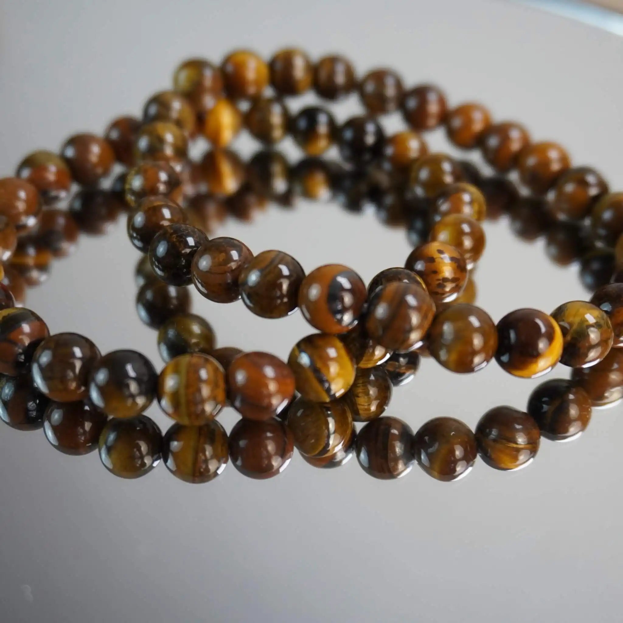 Tigerauge Kugelarmband auf spiegelnder Fläche