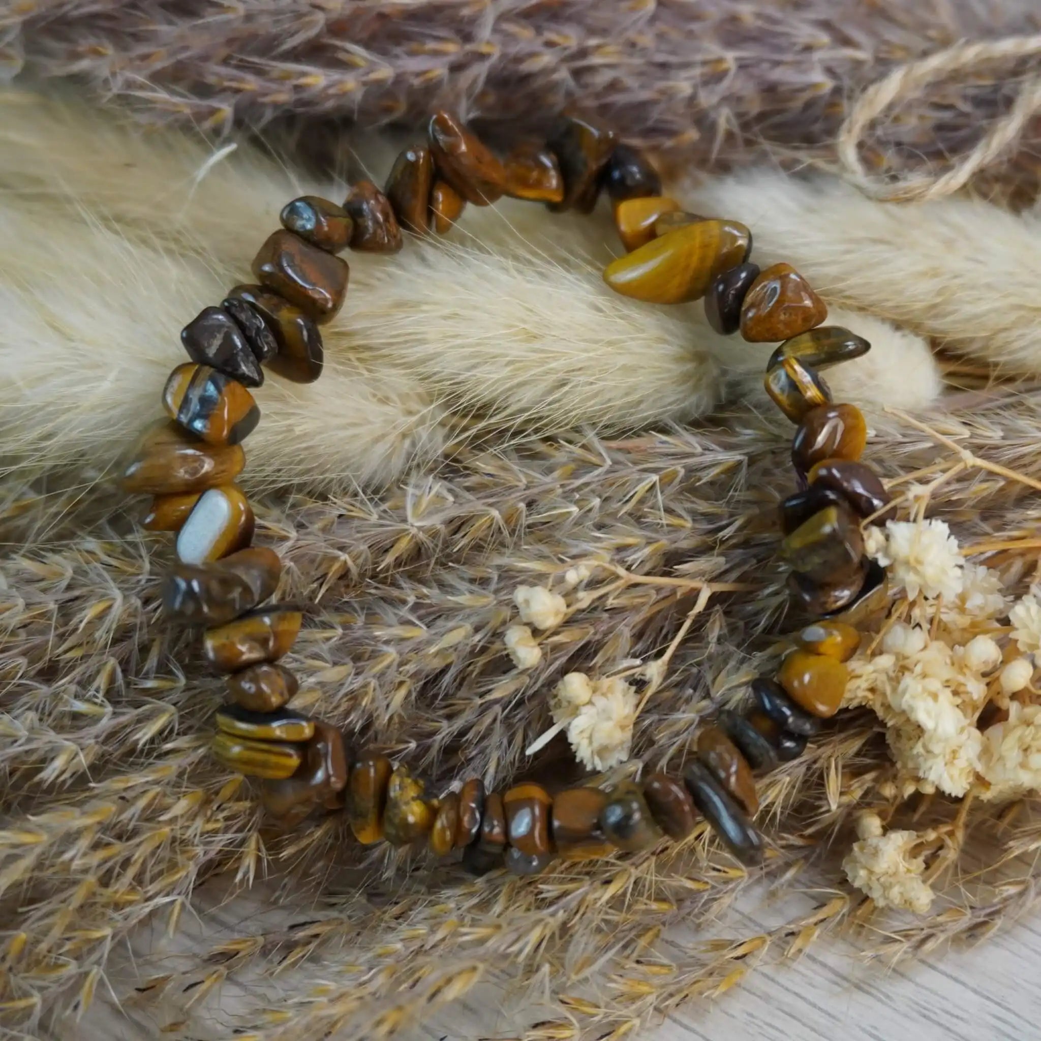 Tigerauge Splitterarmband auf Trockenblumen und Getreide