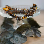 Tigerauge Splitterarmband auf Glasständer mit Blättern