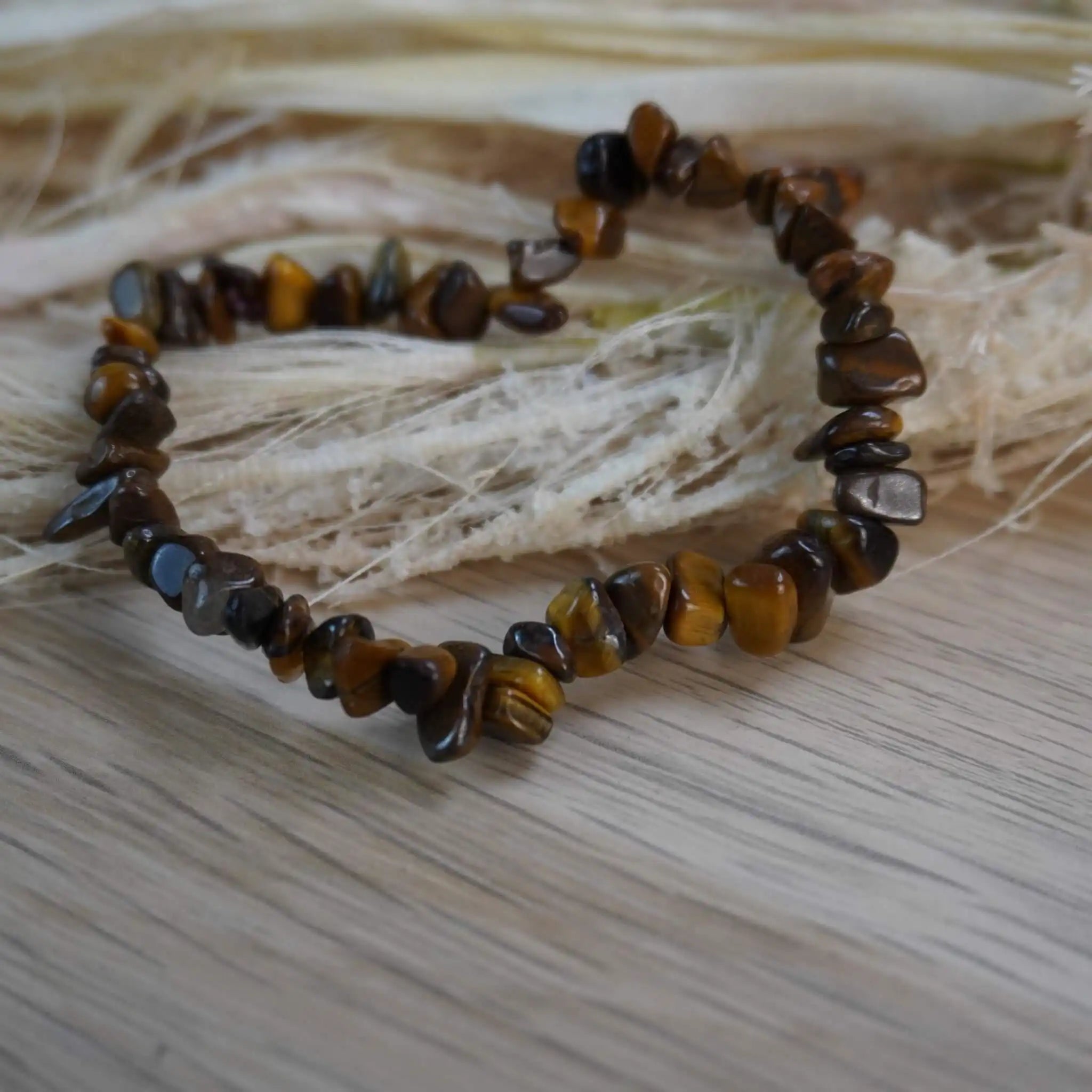Tigerauge Splitterarmband auf hellem Holz mit Naturdeko