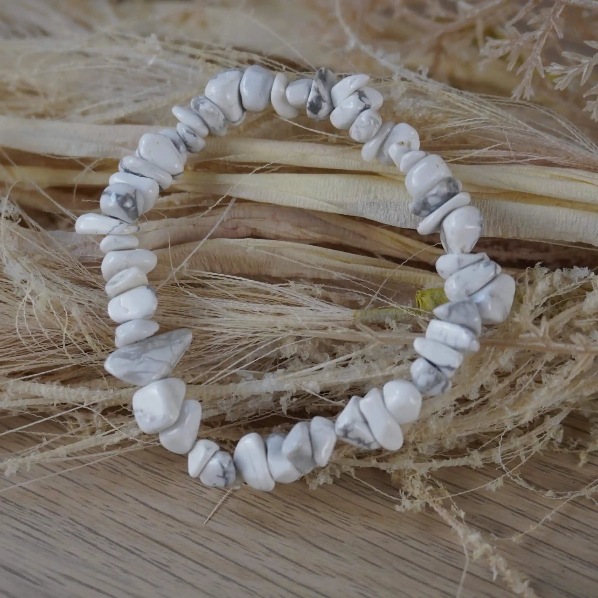 Weißer Jaspis Splitterarmband auf hellem Holz mit Naturfasern