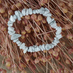 Weißer Jaspis Splitterarmband auf rosa Trockenblumen